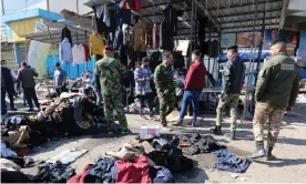  ?? Photograph: Ahmed Jalil/EPA ?? Iraqi security forces patrol the bombing scene at a Baghdad market where 28 people died and dozens were injured.