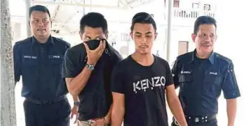  ??  ?? MOHAMAD Zulfikar (kanan) dan Muhammad Asmuhairyl diiringgi anggota polis di Mahkamah
Sesyen Sungai Petani.