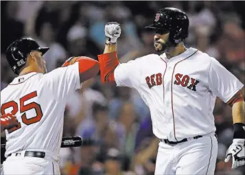  ?? Charles Krupa ?? The Associated Press Red Sox right fielder J.D. Martinez, right, accepts congratula­tions from Steve Pearce after hitting a three-run home run, his Mlb-leading 28th of the year, during a 5-0 victory over the Rangers on Monday in Boston.