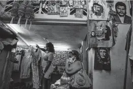  ?? Ramon Espinosa / Associated Press ?? A woman waits to be shown a dress in a private store Thursday in Havana. A new system in Cuba could give private businesses greater legal certainty.