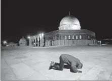  ?? ILLEAN/ THE ASSOCIATED PRESS] ?? A Muslim man prays next to the Dome of the Rock Mosque in the Al Aqsa Mosque compound, Sunday, in Jerusalem's Old City. [MAHMOUD