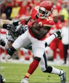  ?? CHARLIE RIEDEL — THE ASSOCIATED PRESS ?? Kansas City Chiefs wide receiver Tyreek Hill (10) breaks a tackle attempt by Philadelph­ia Eagles safety Rodney McLeod (23) during the first half of an NFL football game in Kansas City, Mo., Sunday.