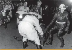  ??  ?? Massen-Krawall: Motorradpo­lizisten schleifen 1965 vor der Ernst-Merck-Halle einen der 3500 randaliere­nden Fans weg.