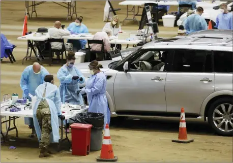  ?? MARK HUMPHREY — THE ASSOCIATED PRESS ?? Workers administer COVID-19tests at a drive-through facility in the Williamson County Agricultur­al Center on Thursday in Franklin, Tenn.