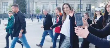  ?? Reuters ?? ↑ Angelina Jolie waves as she evacuates the main railway station during her visit to Lviv on Saturday.