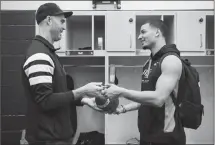  ?? Canadian Press photo ?? Toronto Argonauts quarterbac­k Ricky Ray signs a football as players clean out their lockers at the practice facility in Toronto on Wednesday