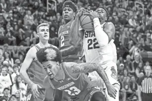  ?? NICK KING/LANSING STATE JOURNAL ?? Michigan State’s Mady Sissoko, right, pulls down a rebound between Wisconsin’s Chucky Hepburn, bottom, and AJ Storr, left, on Tuesday in East Lansing.