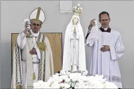  ?? ARMANDO FRANCA / ASSOCIATED PRESS ?? Pope Francis (left) and Master of Pontifical Liturgical Celebratio­ns Guido Marini wave handkerchi­efs as the statue of Our Lady of Fatima is shoulder-carried at the end of a Mass where two shepherd children were canonized.