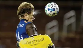  ?? ALBERT CESARE / THE CINCINNATI ENQUIRER ?? FC Cincinnati defender Nick Hagglund (14) heads a shot just over the goal as Columbus Crew defender Jonathan Mensah (4) guards him in the first half of a soccer match on Oct. 14 in Cincinnati.