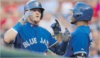  ?? LAURENCE KESTERSON/ THE ASSOCIATED PRESS ?? The Toronto Blue Jays’ Josh Donaldson, left, celebrates with Edwin Encarnacio­n after hitting a home run against the Phillies Tuesday night in Philadelph­ia. The Jays won 8- 5.