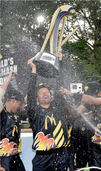  ?? PHOTOSPORT ?? Captain Hamish Marshall lifts the Super Smash trophy aloft while his Firebirds team-mates get the party started.