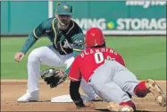  ??  ?? Pete Kozma, de Oakland, pone fuera a Alex Blandino, de Cincinnati