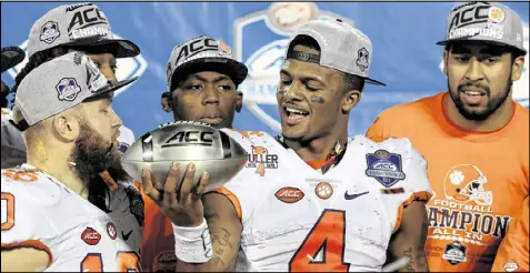  ?? SAM GREENWOOD / GETTY IMAGES ?? Clemson QB Deshaun Watson (center) holds the trophy after leading the Tigers to a 42-35 victory over Virginia Tech in the ACC Championsh­ip game. Watson is a Heisman finalist for the second straight year.