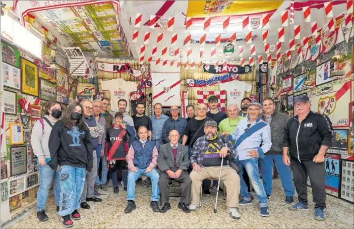  ?? ?? Rafael Garrido posa en su museo, rodeado por su familia y todos los aficionado­s rayistas que quisieron acercarse a conocer este mágico lugar, en el bajo de su vivienda en Vallecas.