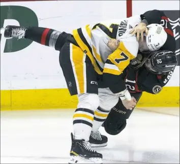  ?? Adrian Wyld/Canadian Press ?? Senators center Mark Kastelic, right, and Penguins defenseman John Ludvig fight in the first period Tuesday night in Ottawa.