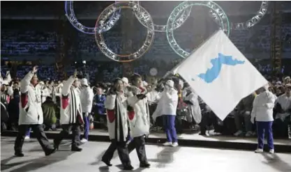  ??  ?? TURIN: In this Feb. 10, 2006 file photo, Korea flag-bearers Bora Lee and Jong-In Lee, carrying a unificatio­n flag, lead their teams into the stadium during the 2006 Winter Olympics opening ceremony in Turin, Italy. The two Koreas continued their joint...