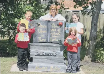  ??  ?? Headteache­r Lucy Griffiths and some of the pupils at South Hetton Primary School with the reading chair.