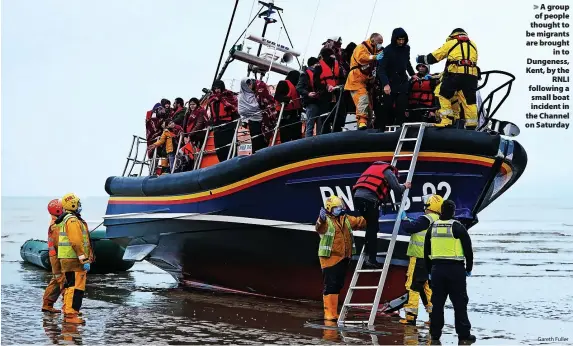 ?? Gareth Fuller ?? > A group of people thought to be migrants are brought in to Dungeness, Kent, by the RNLI following a small boat incident in the Channel on Saturday