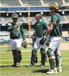 ?? Michael Zagaris / Oakland Athletics/Getty Images ?? The A’s three catchers, Austin Allen (from left), Sean Murphy and Jonah Heim, practice at the Oakland Coliseum in July.