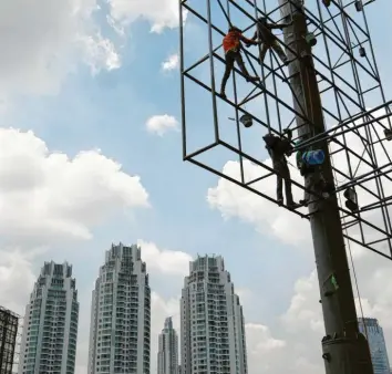  ?? Foto: Bagus Indahon, dpa ?? Eine neues Werbebanne­r muss in Jakarta aufgezogen werden.