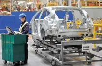  ?? – File Photo ?? TRADE TRUCE: An employee uses a laptop next to a car body at an assembly line at a Ford manufactur­ing plant in Chongqing municipali­ty.