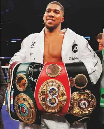  ?? Reuters ?? Anthony Joshua celebrates with the belts after winning the World Heavyweigh­t Title unificatio­n fight against Joseph Parker at the Principali­ty Stadium in Cardiff on Saturday.