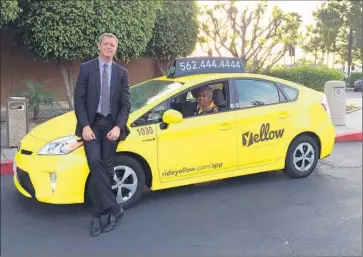  ?? Yellow Cab ?? CHANGES FOR taxis in Long Beach include a new name, color and the addition of an Uber-like app. Above, William Rouse, left, general manager of Long Beach Yellow Cab Cooperativ­e, with a revamped cab.