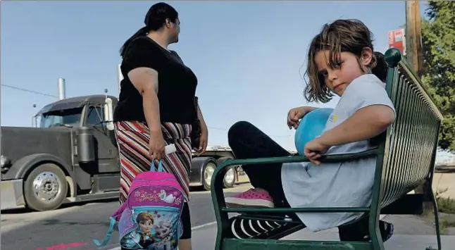  ?? CRAIG F. WALKER / GETTY IMAGES ?? L’ Olivia, de 9 anys, amb la seva mare Faith, esperant l’autobús a Denver (Colorado), on van ser ateses per una missió de rescat de famílies pobres