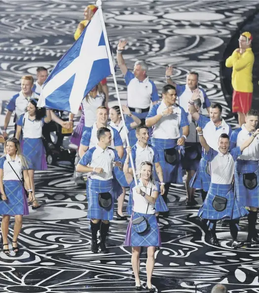  ?? PICTURES: GETTY IMAGES; PA ?? Eilidh Doyle leads out Team Scotland, above, while Mark Knowles had the same honour for the Australian team. The Gold Coast Games opening ceremony included music and dance performanc­es both modern and traditiona­l, plus an Aboriginal ceremony, far left....