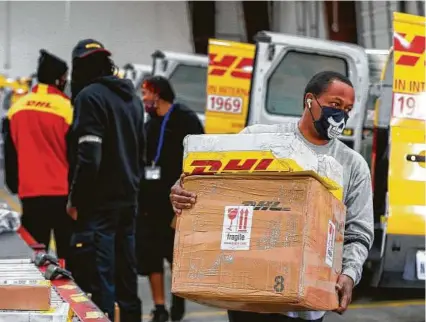  ?? Godofredo A. Vásquez / Staff photograph­er ?? DHL crews work in Houston. Major couriers dealt with an unpreceden­ted surge in demand for holiday shipping due to the pandemic. E-commerce saved the day for retailers last year.