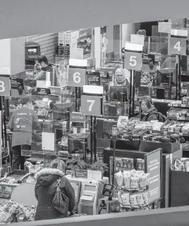  ?? ?? People pay for their items at a grocery store in Toronto.
REUTERS