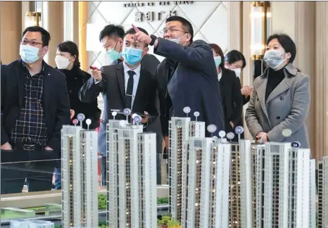  ?? ZHAO QIRUI / FOR CHINA DAILY ?? Potential homebuyers look at property models in Huai’an, Jiangsu province.