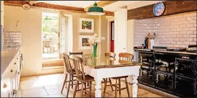  ??  ?? Country cooking: The giant kitchen with its Aga and beamed ceiling