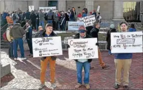  ?? PETE BANNAN – DIGITAL FIRST MEDIA ?? Three supporters of U. S. Rep. Ryan Costello, R- 6, hold up their signs along High Street in front of about 100anti- tax bill protesters who turned out for a rally at noon on Monday on the steps of the Historic Chester County Courthouse to urge...