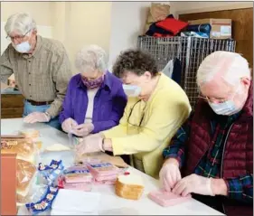  ?? PHOTOS PROVIDED ?? Volunteers pack and distribute food to those dealing with homelessne­ss in Marshall County.