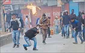  ?? AP PHOTO ?? A Kashmiri protester throws petrol bombs at Indian policemen during a protest in Srinagar on Friday. Police fired tear gas and rubber bullets to disperse protesters demanding the disbanding of village defence committee, a body of civilian volunteers...
