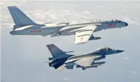  ?? (AFP) ?? A Taiwanese F-16 fighter jet flying next to a Chinese H-6 bomber (top) in Taiwan’s airspace