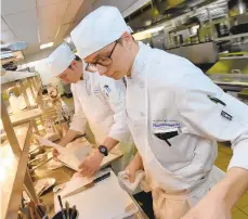  ?? AMY SHORTELL/THE MORNING CALL ?? Matthew Kirby, left, and Thomas Traupman have been selected to compete in the Internatio­nal Young Chefs Associatio­n Challenge in Ningbo, China. Here, they work on a meal.