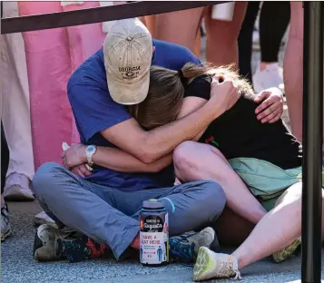  ?? PHOTOS BY NELL CARROLL FOR THE AJC ?? Students hug Monday at the Tate Plaza to pay tribute to a UGA student who died Wednesday and Augusta University nursing student Laken Riley, who was killed Thursday on the UGA campus.