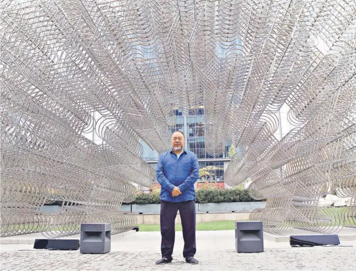  ??  ?? ► El artista chino posó ayer ante las 1.254 bicicletas de acero que forman parte de su instalació­n Forever Bicycles (2015), emplazada afuera de CorpArtes.