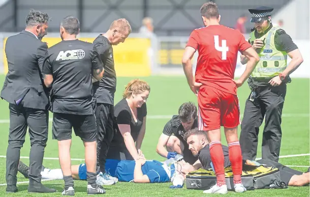  ?? Photograph by Darrell Benns ?? TREATMENT: Jordon Brown on the pitch receiving medical attention after an accidental collision with Aberdeen player Andrew Considine.