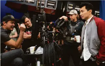  ?? Jasin Boland / Marvel Studios ?? “Shang-Chi” director Destin Daniel Cretton (left) and fight instructor Alan Tang confer with a camera operator and Liu on the movie’s set in Australia.