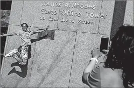  ?? [ERIC ALBRECHT/DISPATCH] ?? Agnes Igodan celebrates finishing Saturday’s 880-stair climb outside the Rhodes Tower while friend Prashanthi Papireddy records her celebrator­y jump.