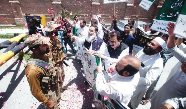  ?? Associated Press ?? ↑
People throw flowers on soldiers during a rally to show solidarity with Pakistan’s army in Peshawar on Saturday.