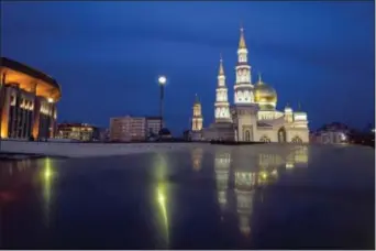  ?? ALEXANDER ZEMLIANICH­ENKO - THE ASSOCIATED PRESS ?? The minarets of the Moscow Cathedral Mosque, right, rise next to a sports arena built for the 1980 Moscow Olympics in Moscow, Russia. For an Associated Press correspond­ent returning to the Russian capital on an extended assignment for the first time...