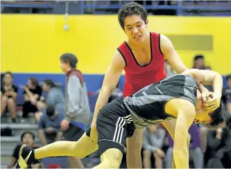  ?? CLIFFORD SKARSTEDT/EXAMINER FILES ?? Kenner's Dan McLean, top, grapples with opponent Jacob Curtin during the 17th annual Kenner Invitation­al Wrestling Tournament on Wednesday at the Kenner Collegiate gym on Monaghan Rd. McLean won bronze in his weight class at the tourney. See more...