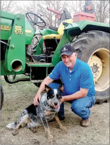  ?? Staff photograph by Sally Carroll ?? Perry Mason plays with Ivan, his dog, on his farm near Longview, Mo. The PRHS FFA leader and Ag teacher has taught and worked with students at Pea Ridge High School for 27 years.