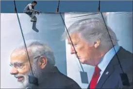  ?? AP PHOTO ?? A man works on a hoarding welcoming US President Donald Trump in Ahmedabad, on Thursday.