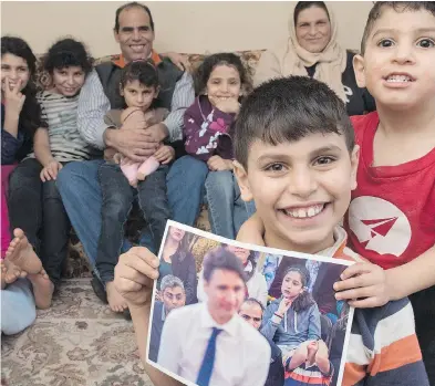  ?? STEPHEN MACGILLIVR­AY / THE CANADIAN PRESS ?? Abdel Kader Al Shaikh holds the photo of him and the PM that got so much media attention last week.