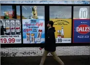  ?? HELEN H. RICHARDSON — THE DENVER POST ?? A pedestrian walks past advertisem­ents for liquor at a local liquor store along Colfax avenue in Denver on Jan. 3, 2024. Colorado has a high rate of alcohol-related deaths, ranging